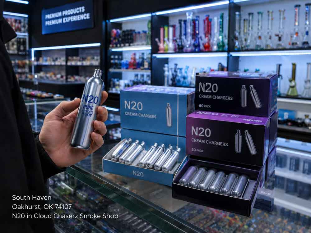 A customer holds a nitrous oxide canister next to boxes of N20 Sapulpa cream chargers inside a smoke shop.