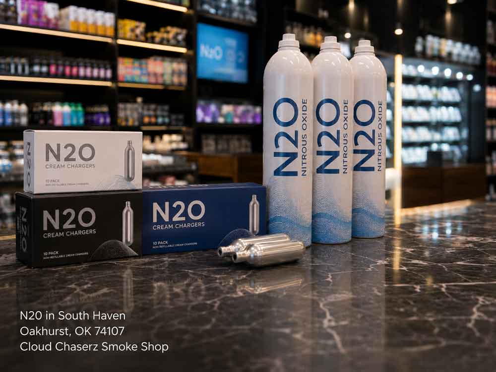 Large nitrous oxide tanks and 10-packs of N20 Sapulpa cream chargers on a marble counter at a smoke shop.