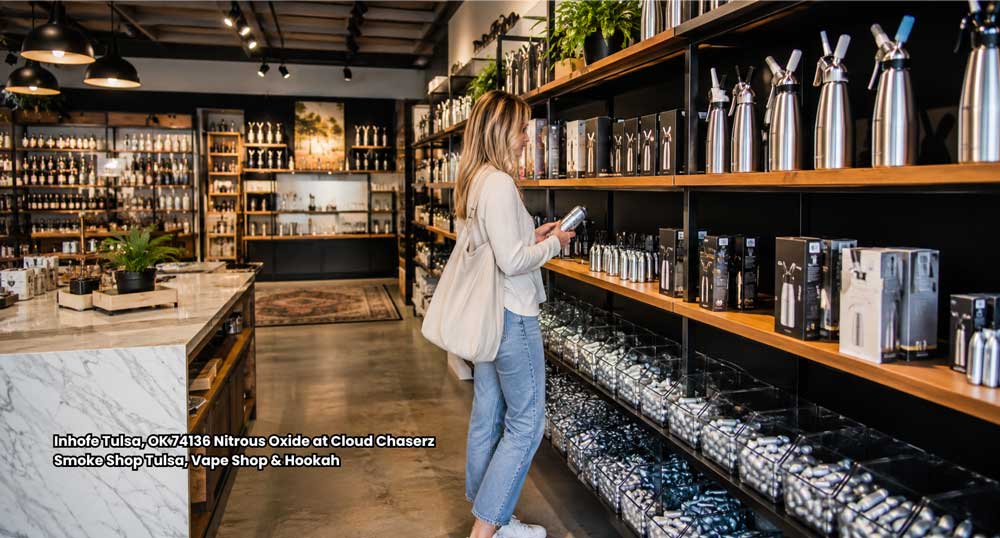 Customer inspecting whipped cream dispensers near nitrous oxide shelves at Cloud Chaserz Smoke Shop in Tulsa, OK.