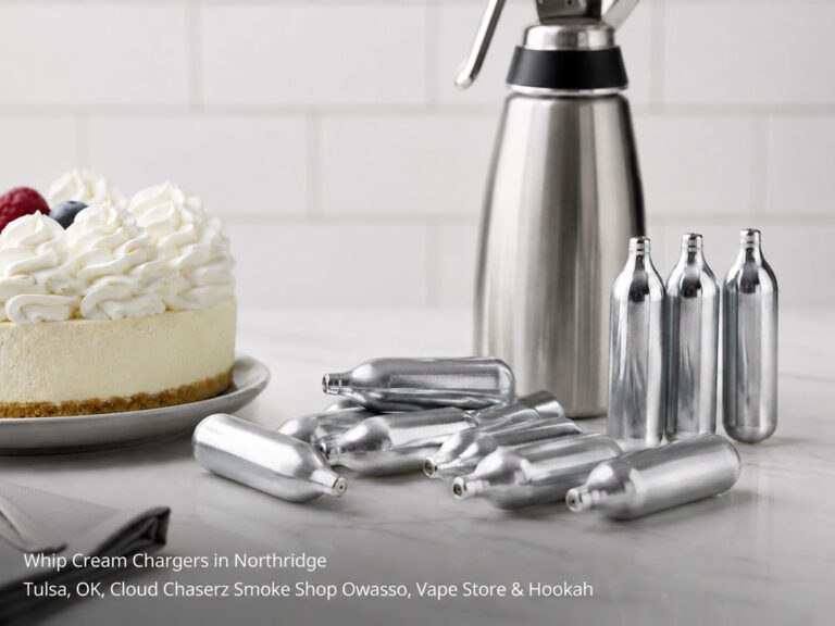 Scattered silver whip cream chargers Owasso Northridge shop display beside a freshly topped gourmet cheesecake.