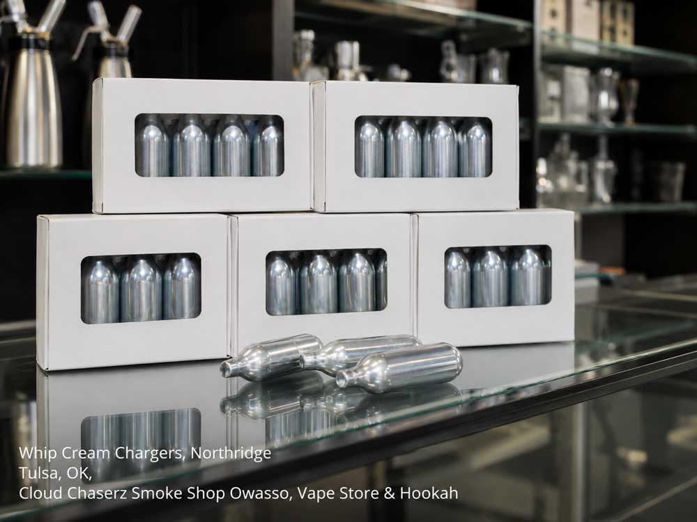 Stocked boxes of premium whip cream chargers Owasso smoke shop selection displayed on a glass retail counter.