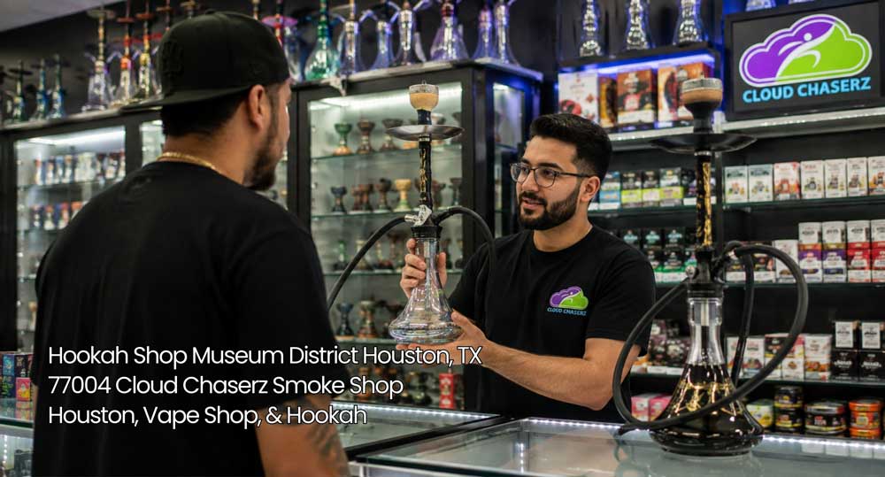 Attentive staff member displaying a black glass pipe to a shopper at a hookah shop Houston near the Museum District.