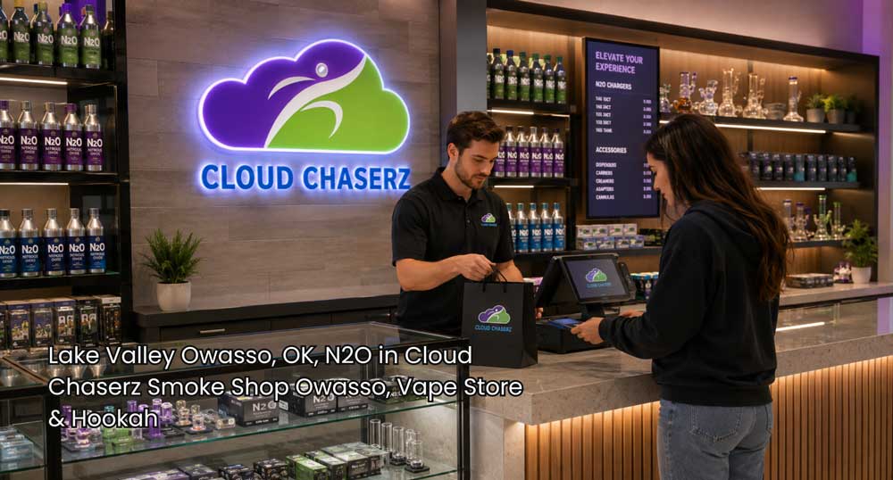 Cloud Chaserz employee completes a customer purchase beside N2O charger displays in a modern n2O Owasso smoke shop.